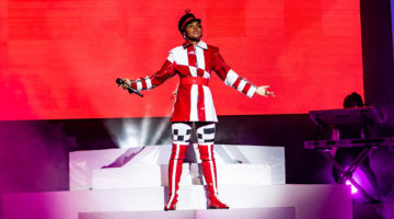 janelle-monae-on-stage-wearing-red-marching-band-outfit-singing-to-crowd