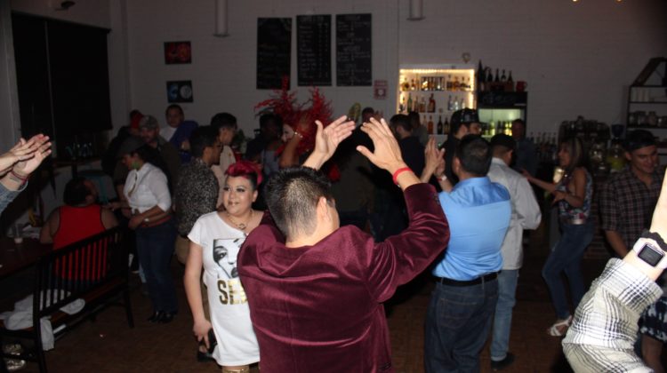A crowd of people dance in a room.