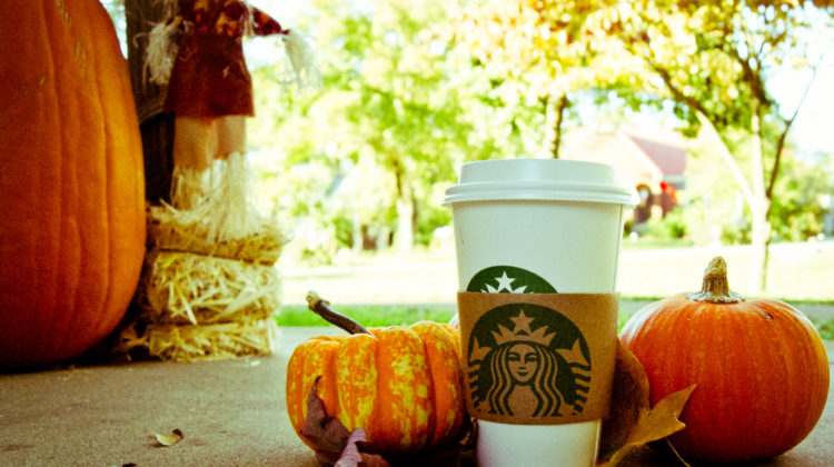Starbucks cup against an autumn background with pumpkins
