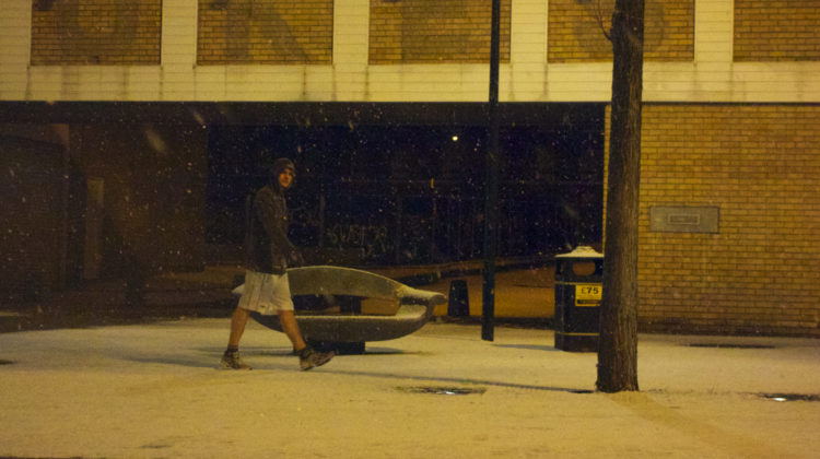 A man in shorts walks through the snow