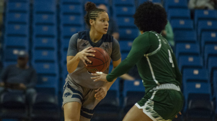 Essence Booker wears all grey and blue as she engages with a Sacramento State defender. The defender is wearing all green with white accents.