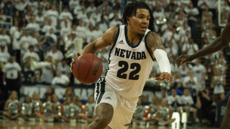 Jazz Johnson, wearing all white, dribbles a ball during a match in Lawlor Events Center.