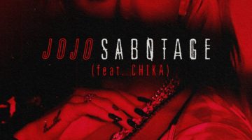 JoJo's single cover for "Sabotage (feat. CHIKA)." In red lighting, JoJo is looking to the left and the name of the single is written across her face.