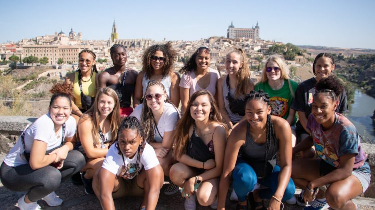 The Nevada women's basketball team poses in front of a Spanish city while on a summer trip to the country.