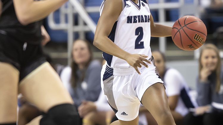 Da'ja Hamilton runs up the court during a game at Lawlor Events Center. Hamilton is wearing an all white basketball uniform with a number two in the middle of her jersey.