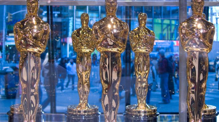 Display of five gold Oscar awards.