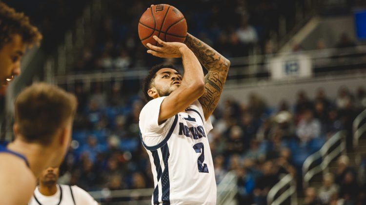 Jalen Harris shoots a free throw in a game in Lawlor Events Center. Harris is wearing an all white uniform with blue accents including the word "Nevada" and a No. 2 across his chest.