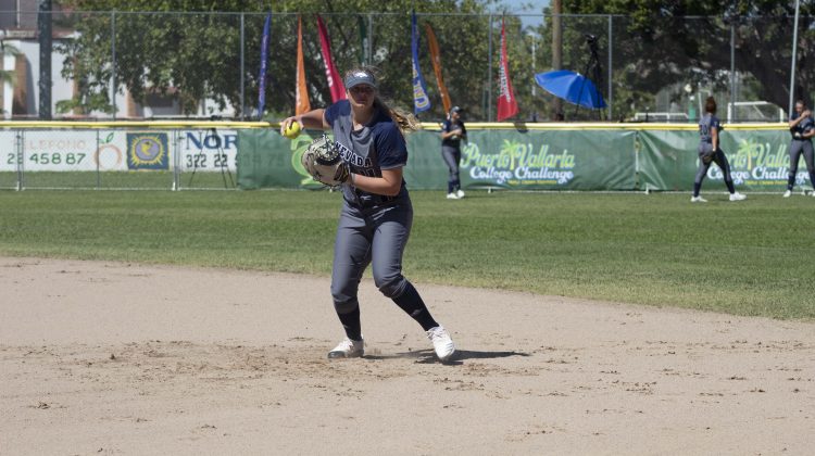 Charli McLendon warms up ahead of the Puerto Vallarta College Challenge. She is wearing a blue and grey softball uniform.