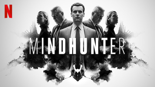 Five men in suits are lined up, one of them is looking forward. The title "Mindhunter" is written across the middle of the picture.