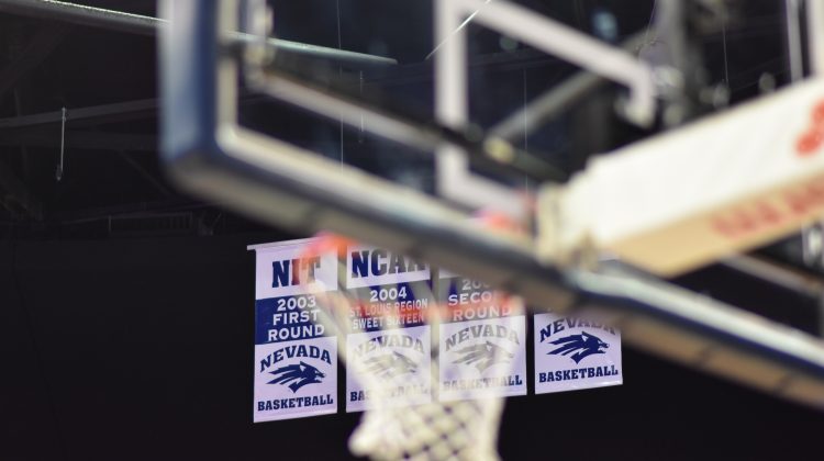 Basketball hoop out of focus with Nevada Basketball banners in the background