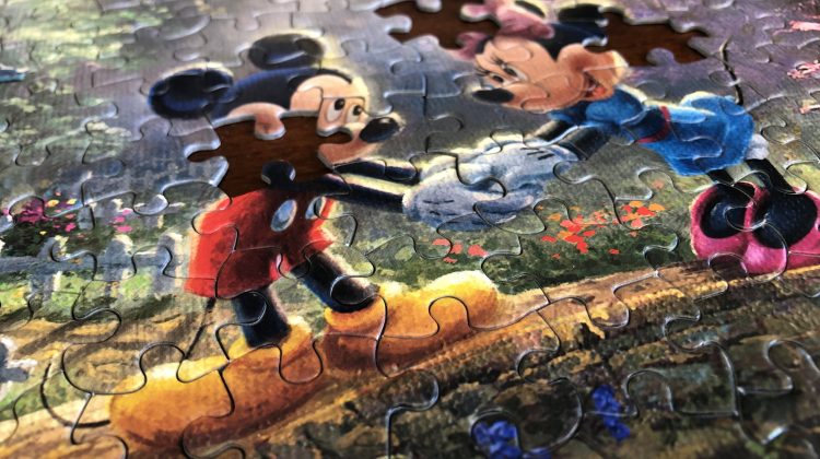 A mickey mouse jigsaw puzzle with a few pieces missing