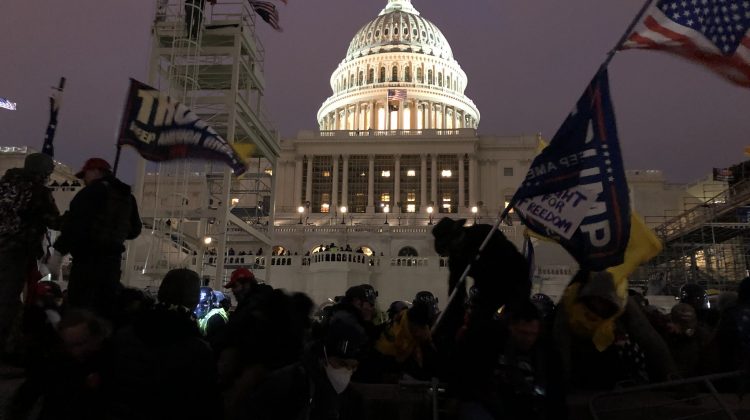 Protestors waving Trump flags stand in front of the capitol building in Washington D.C