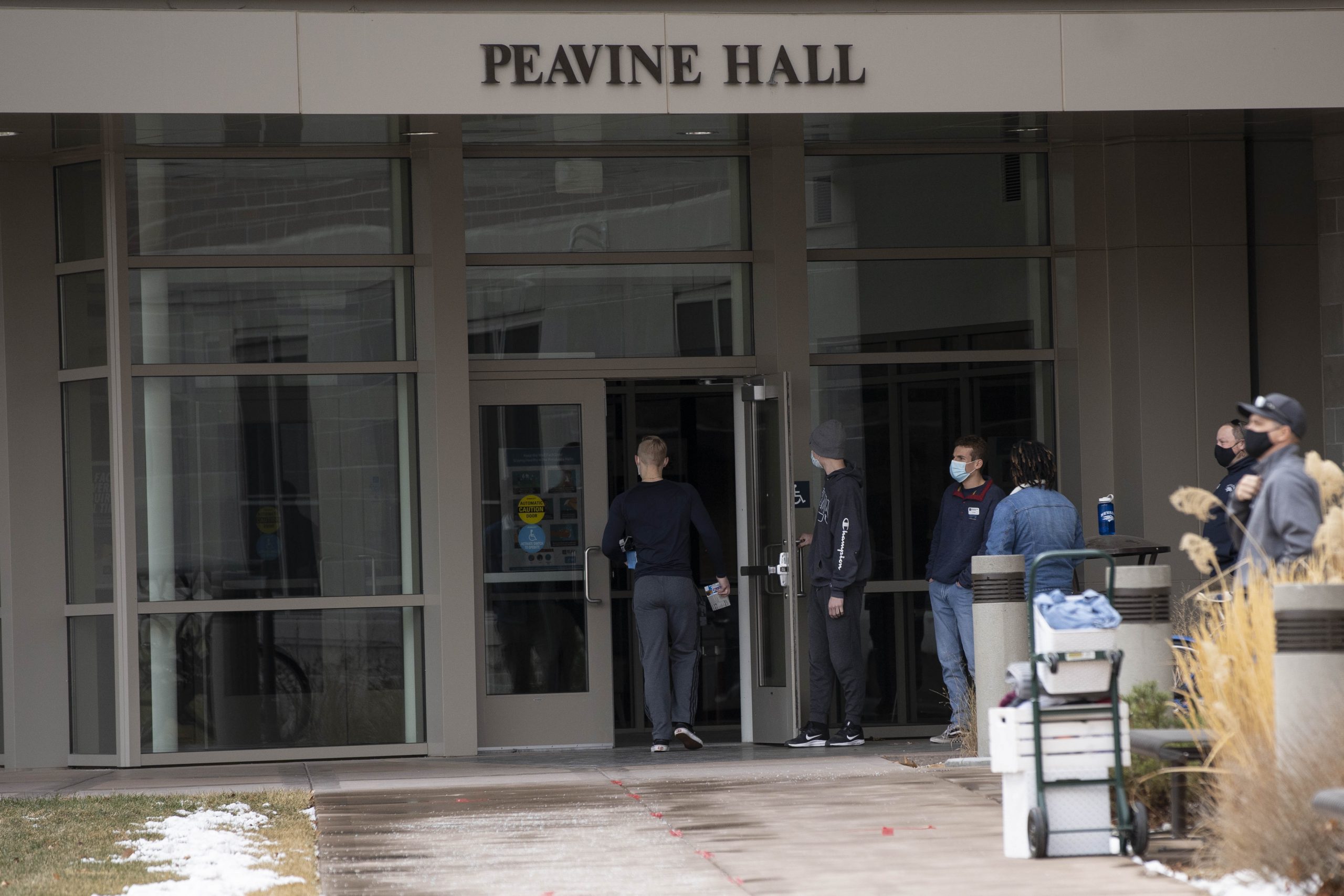 Students move in to Peavine Hall while wearing masks as part of COVID-19 precautions