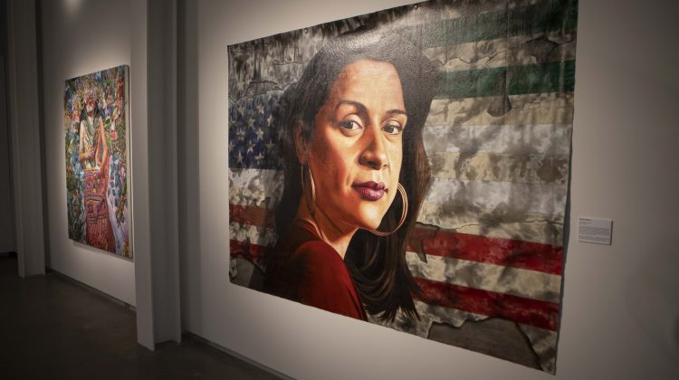 Image of an art piece of a Latinx woman in front of a USA flag.