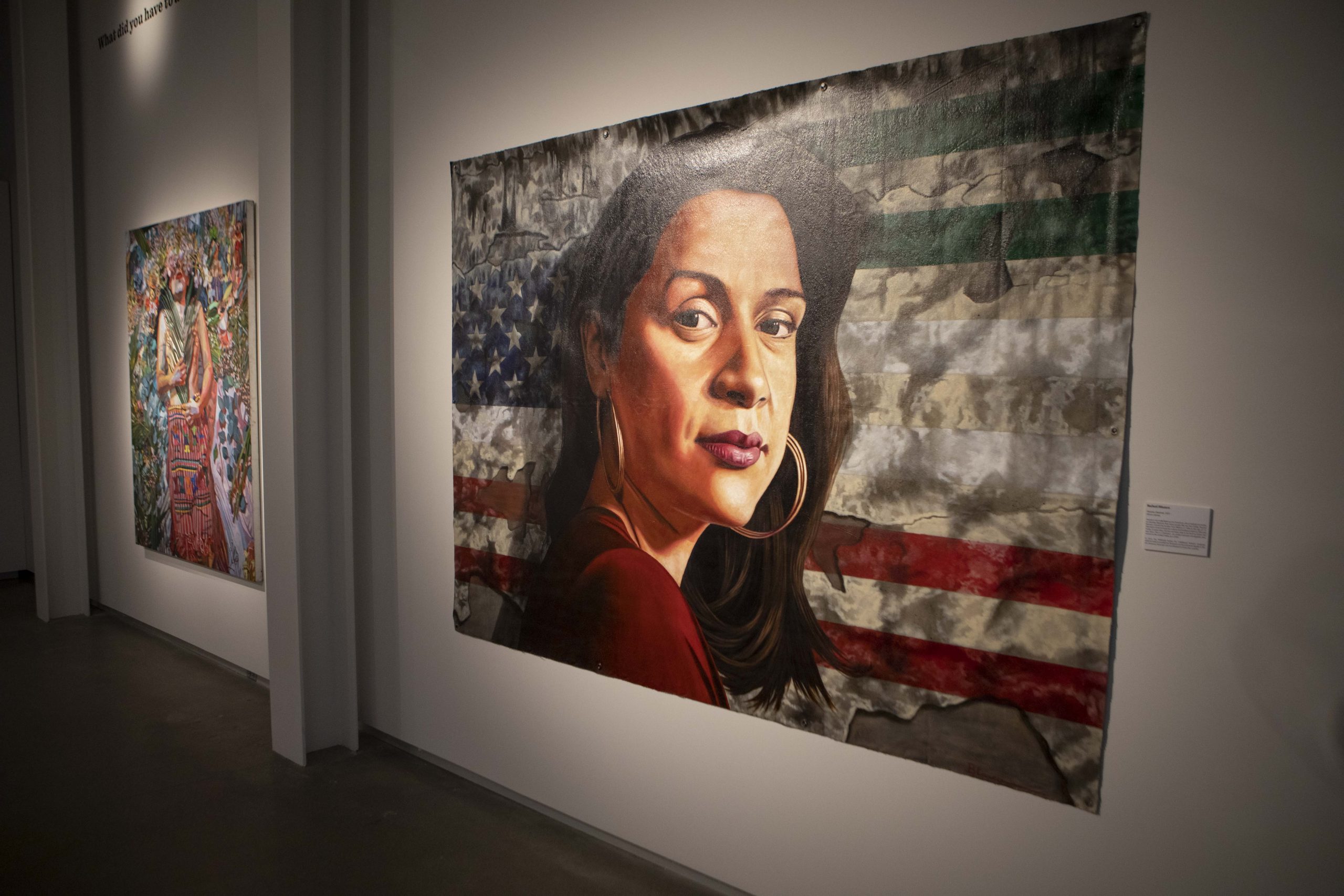 Image of an art piece of a Latinx woman in front of a USA flag.