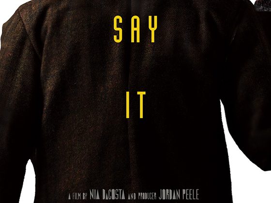Man facing his back to the camera with black coat and fur lined, with words "Say it" and "Candyman" in yellow with further movie information in white.