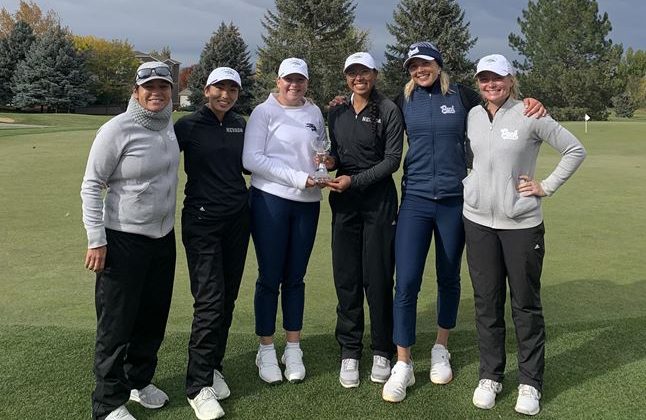 The women's golf team holds the second place trophy.
