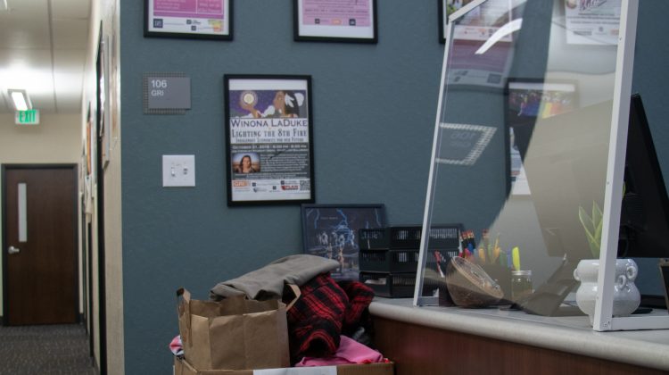 Cardboard box with a sign for clothing donations sits in front of the GRI suite desk in the Thompson Building.