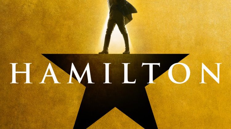 A shadow figure standing on black star with a gold background. The word "Hamilton" is in white in the center of the picture.